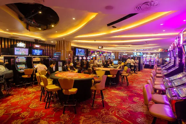 A young woman relaxing with her phone while dynamic casino elements float around her, illustrating the smooth mobile experience offered by the SUPERJILI app.